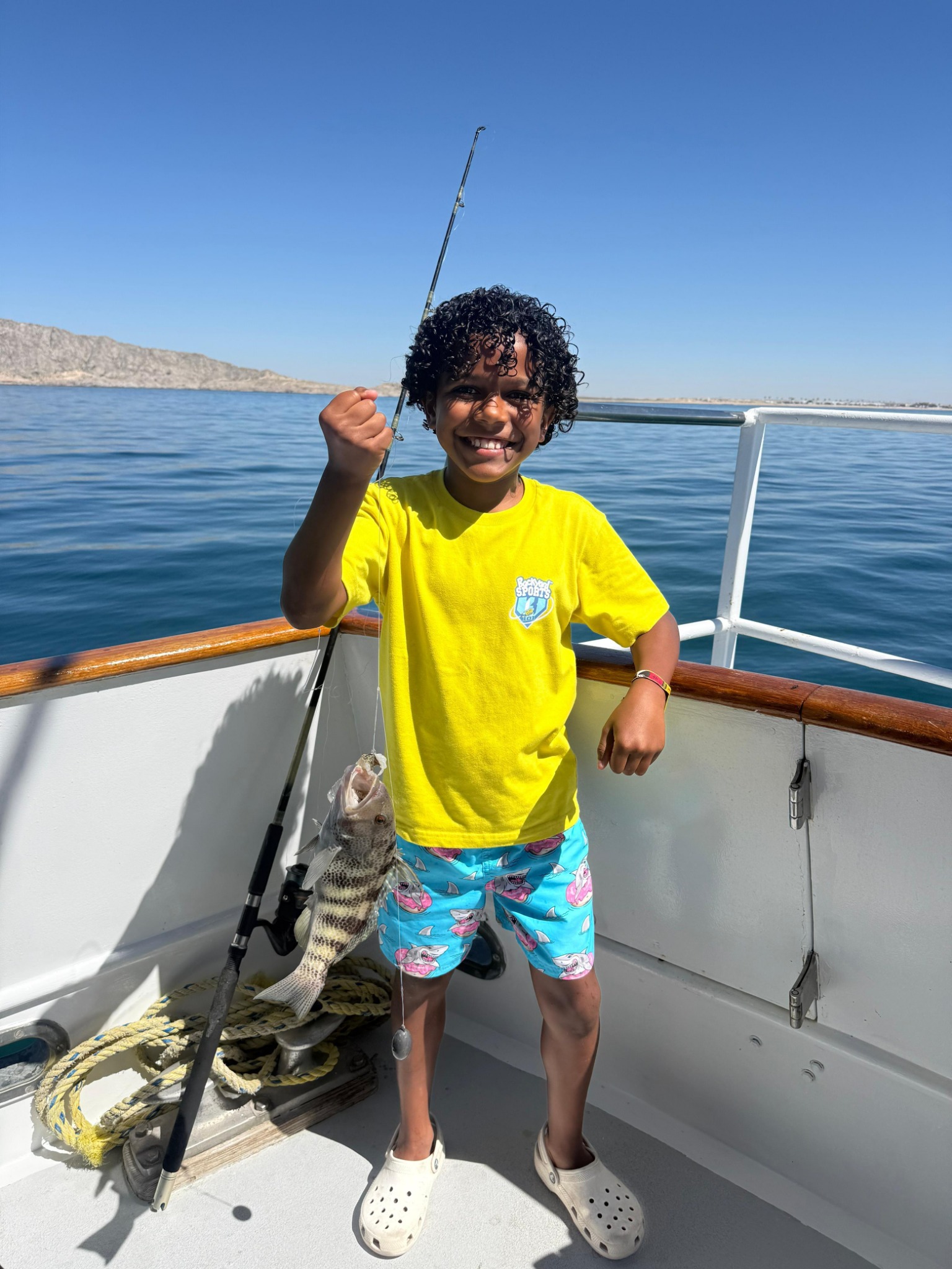 Young angler smiling with a fish aboard WanderLust