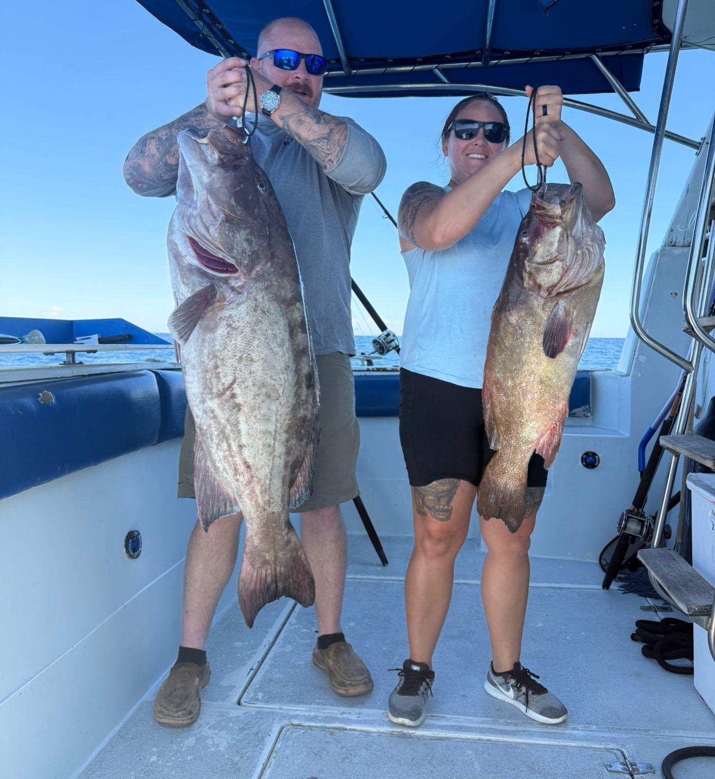 Two anglers holding massive grouper after a Rocky Point deep-sea trip